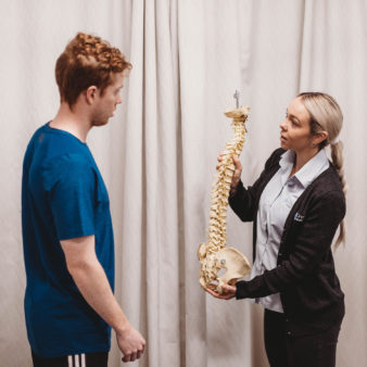 Physio demonstrating back pain to patient
